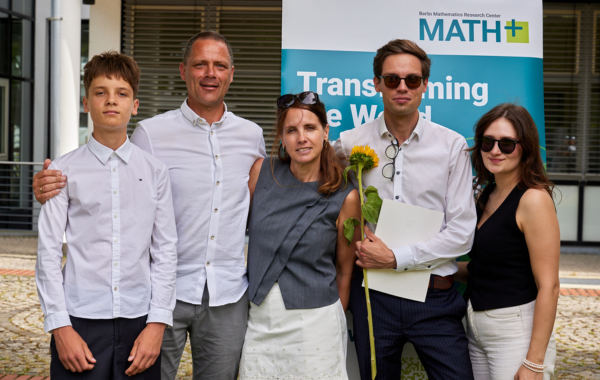Jonas Bresch with family and guests at the BMS certificate ceremony, holding a certificate and sunflower.